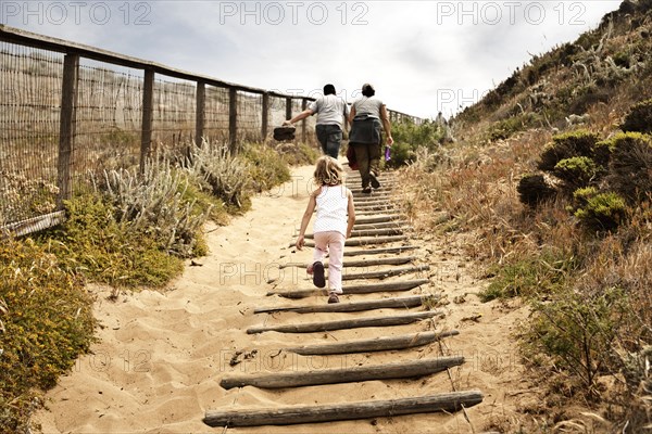 Family walking up sandy staircase