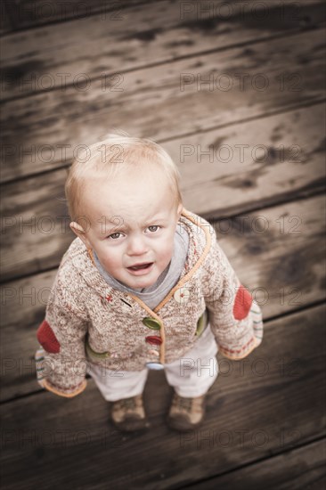 Frowning Caucasian boy standing outdoors