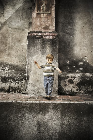 Mixed race boy walking on urban walkway