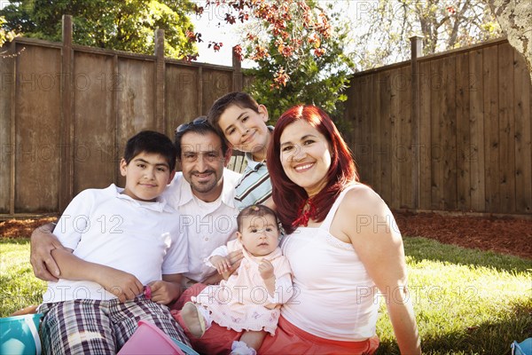 Hispanic family sitting together in backyard