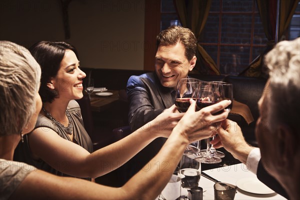 Couples toasting with red wine in restaurant
