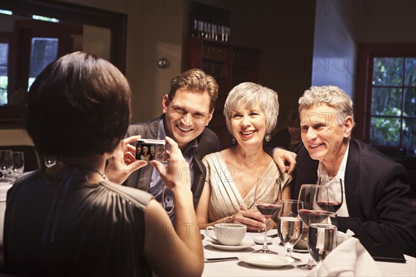 Woman photographing friends in restaurant