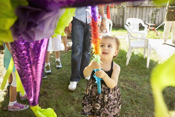 Hispanic girl trying to hit pinata