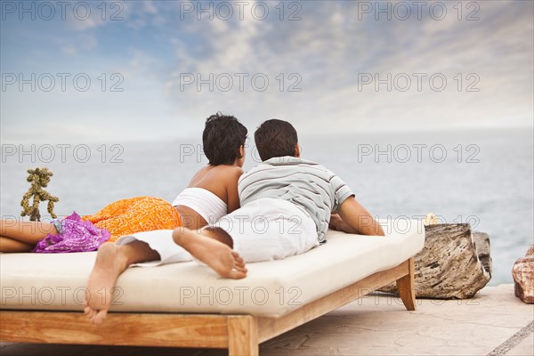 Hispanic couple relaxing near ocean