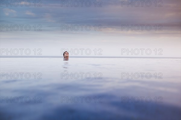 Hispanic woman soaking in swimming pool