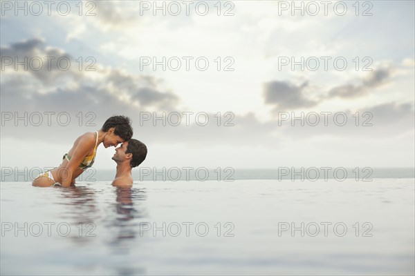 Hispanic couple enjoying swimming pool