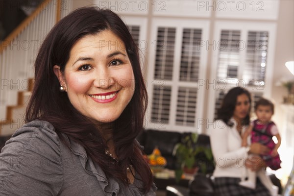 Hispanic woman in living room with family