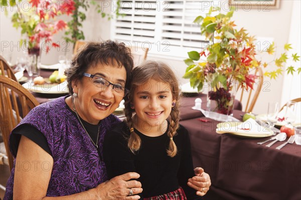 Hispanic grandmother and granddaughter at Thanksgiving dinner