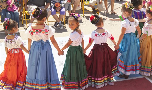 Hispanic girls dancing in costumes