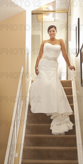 Hispanic bride standing on staircase