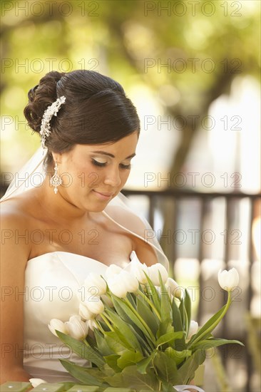 Hispanic bride holding bouquet