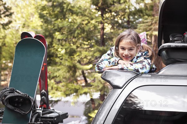 Mixed race girl on top of car