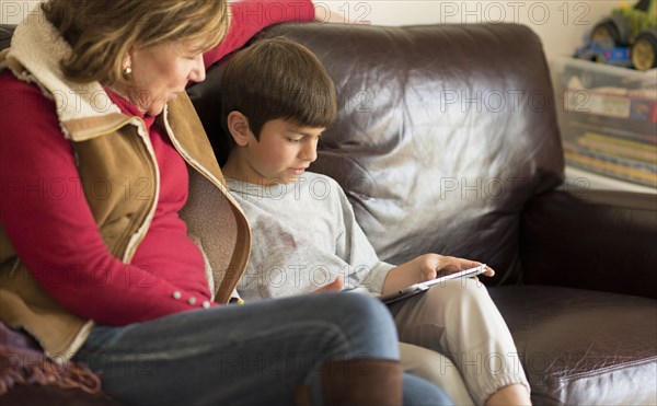 Hispanic mother and son using digital tablet