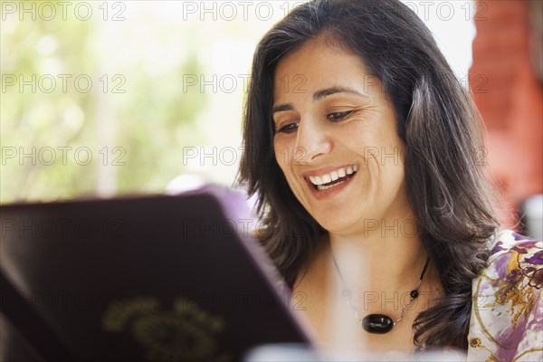 Hispanic woman looking at restaurant menu