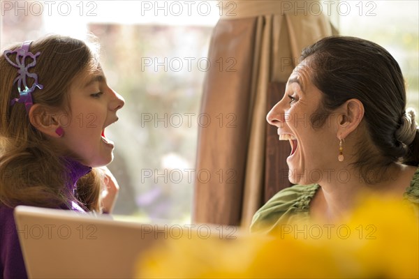 Mother and daughter talking at computer