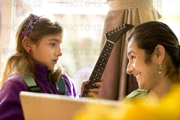 Mother and daughter talking at computer