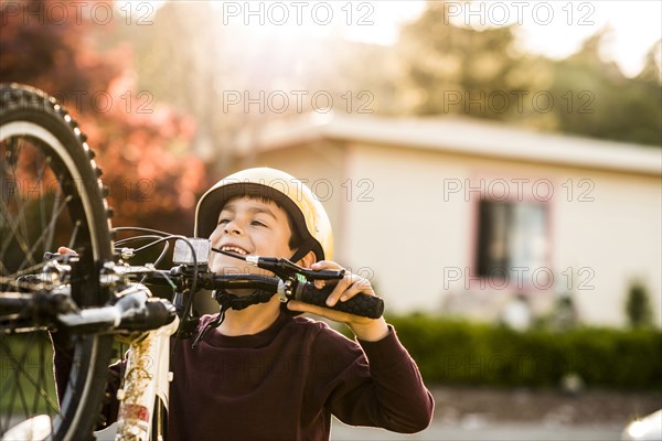 Mixed race boy playing with mountain bike