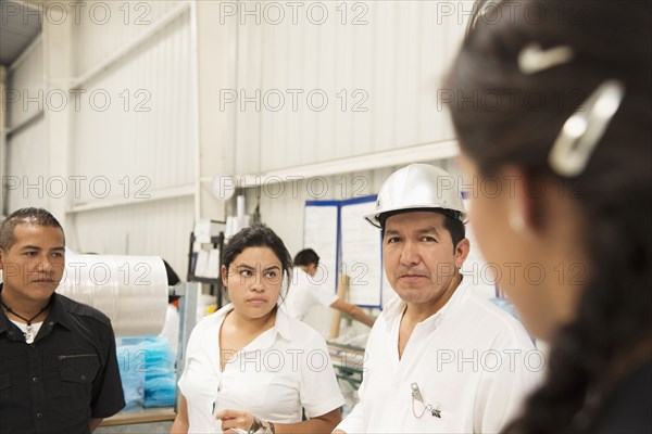 Workers talking in manufacturing plant