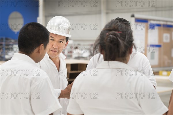 Workers talking in manufacturing plant