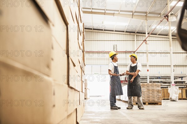 Workers talking in manufacturing plant