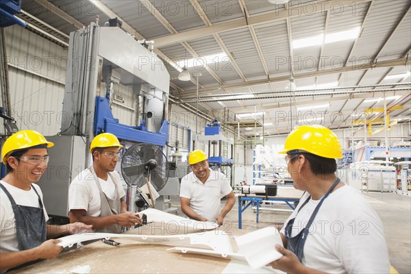 Workers talking in manufacturing plant