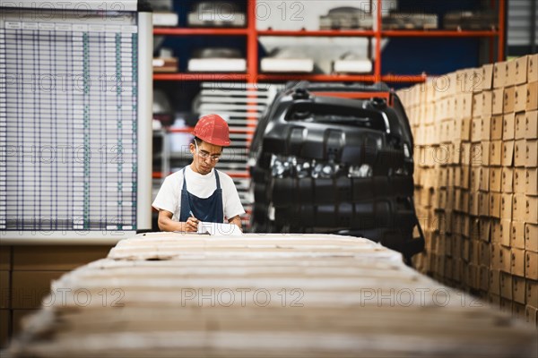 Worker examining product in manufacturing plant