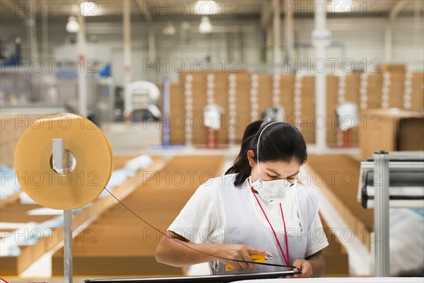 Worker wearing face mask in manufacturing plant