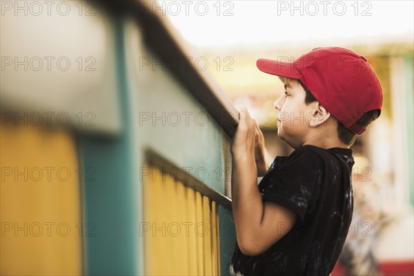 Mixed race boy climbing on banister