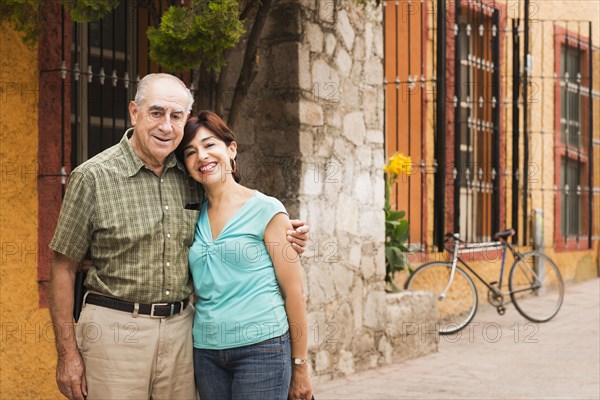 Hispanic couple smiling on city street