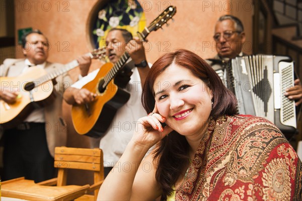 Hispanic woman in restaurant with Mariachi band