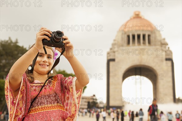 Mixed race girl taking pictures on city street