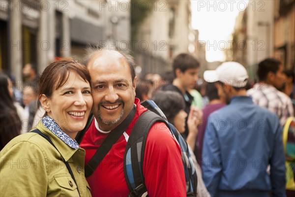 Hispanic couple smiling on city street