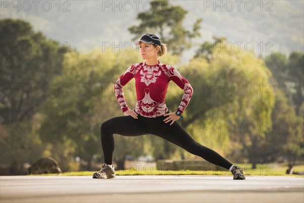 Caucasian runner stretching in park