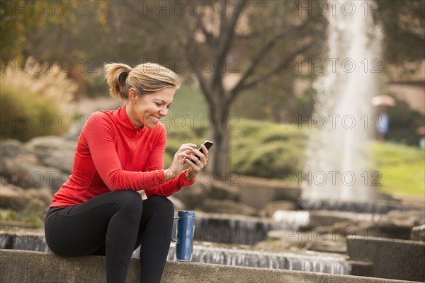 Caucasian woman using cell phone in park