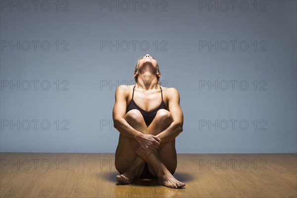 Caucasian woman practicing yoga in studio