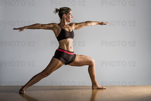 Caucasian woman practicing yoga in studio