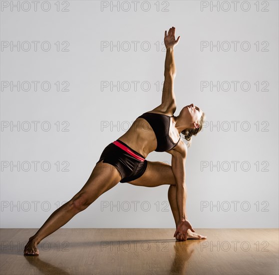 Caucasian woman practicing yoga in studio