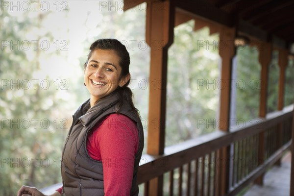 Hispanic woman smiling on porch