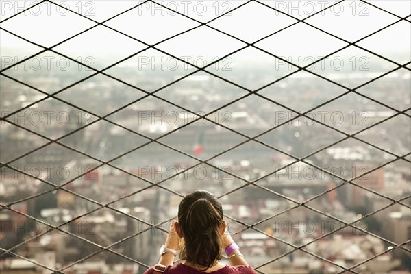 Hispanic woman admiring view from skyscraper