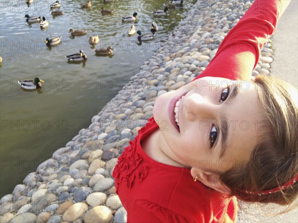 Mixed race girl smiling by river