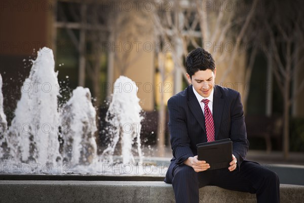 Hispanic businessman using tablet computer