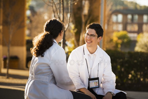 Hispanic doctors talking outdoors