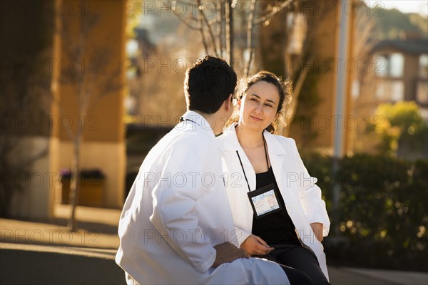 Hispanic doctors talking outdoors