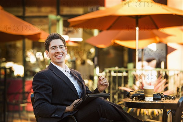 Hispanic businessman working at cafe