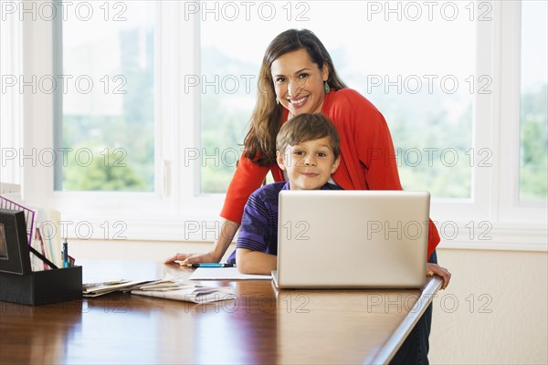 Mother and son using laptop together