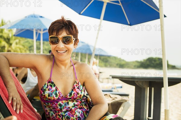 Hispanic woman smiling in lounge chair