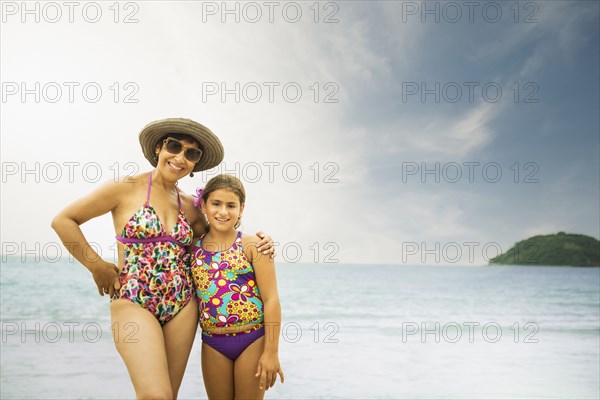 Mother and daughter smiling on beach