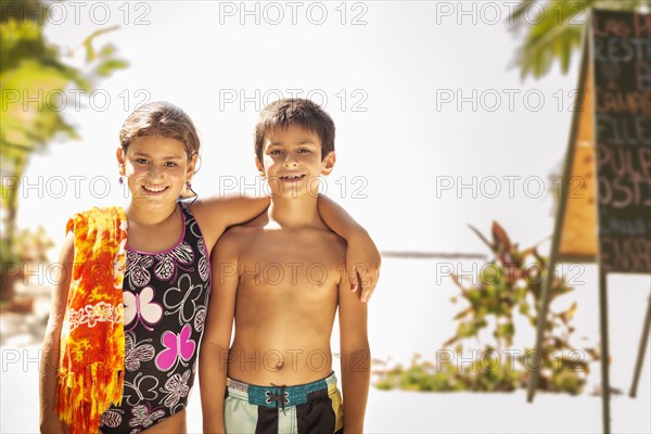 Mixed race children smiling on beach