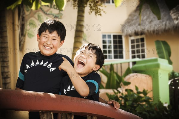 Hispanic boys laughing in courtyard