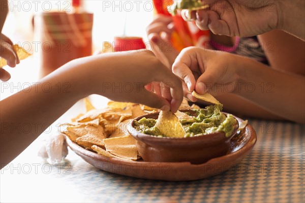 Children eating chips and guacamole